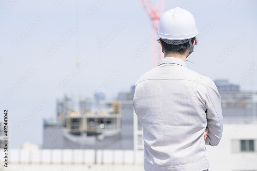 作業着姿の男性の後ろ姿
