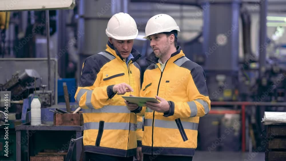 Two engineers at an industrial plant. Two workers control the work at the factory. Manufacture of cutting tools. Drill manufacturing plant. Two engineers at an industrial plant. Two workers control the work at the factory. Manufacture of cutting tools. Drill manufacturing plant.