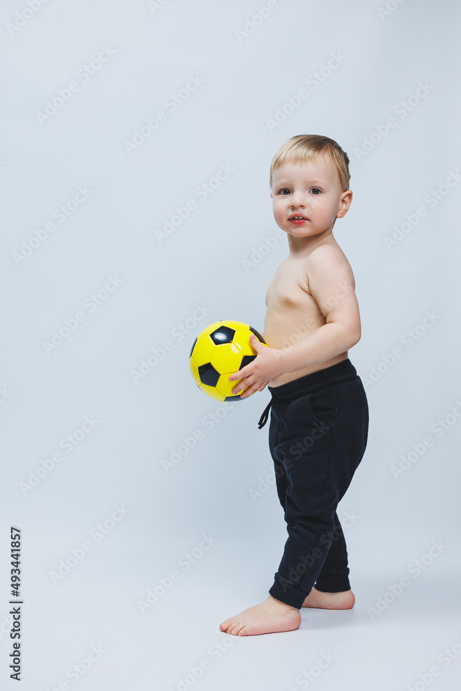 Fan boy holding a soccer ball in his hands, isolated on a white background. newbie in football, sport for kids. Little athlete. Fan boy holding a soccer ball in his hands, isolated on a white background. newbie in football, sport for kids. Little athlete.