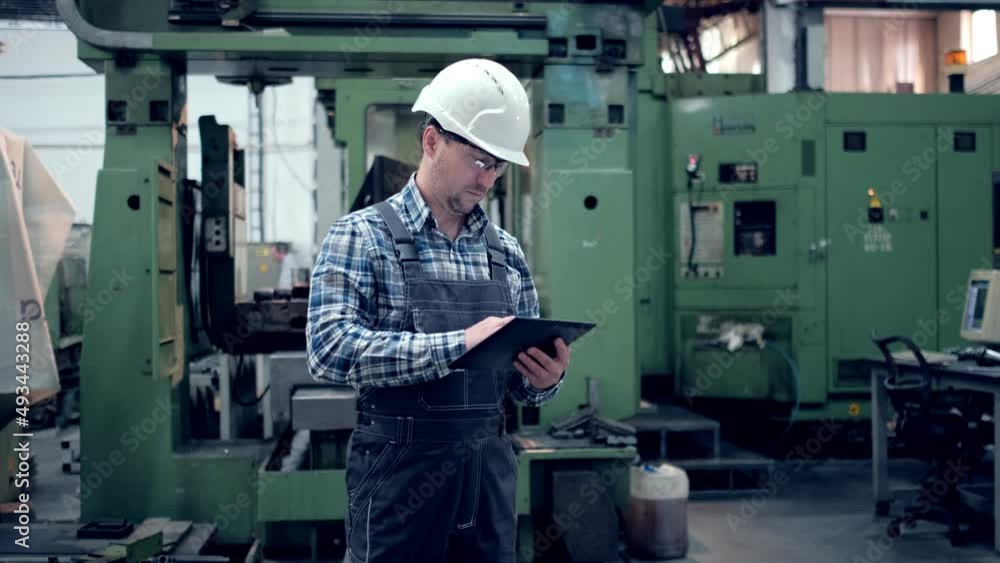 Engineer Is Using Tablet Pc In Factory. Slow-Motion. Engineer Is Using Tablet Pc In Factory. Slow-Motion.