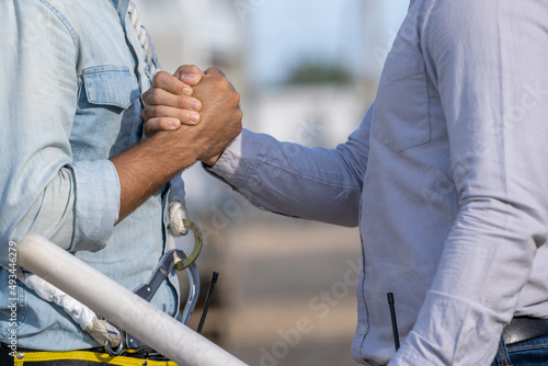 Close up engineer and architect are shaking hands after finishing up meeting in construction site,Construction Contractors building a new home.