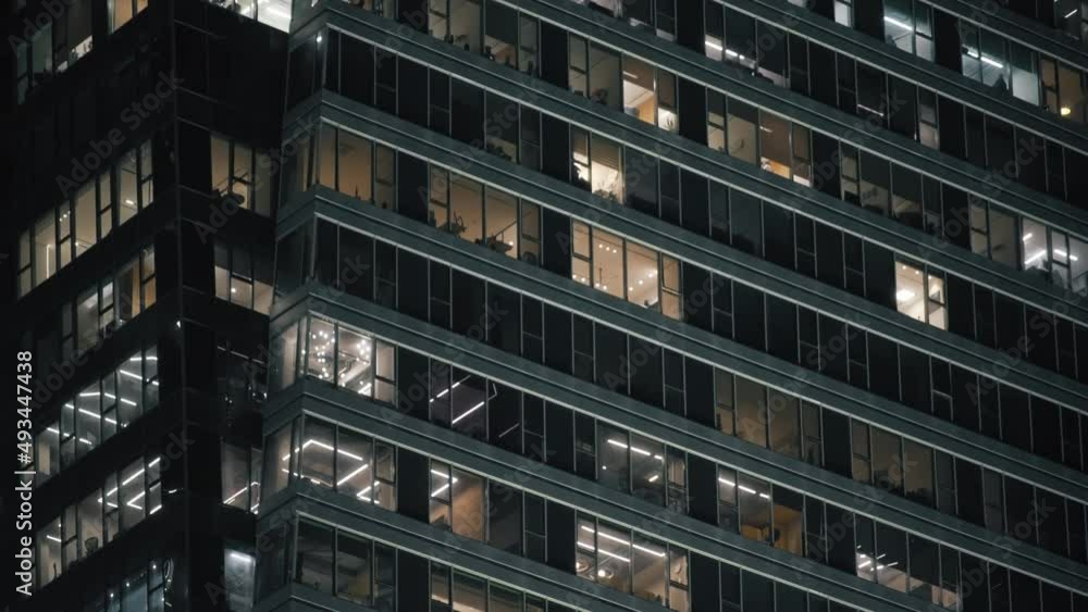 High-rise business building with glass facade in downtown at night. Tilt up. High-rise business building with glass facade in downtown at night. Tilt up.