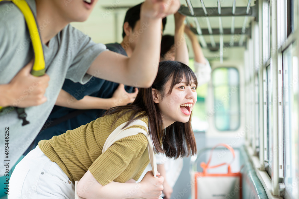 電車の窓から外を見る学生 電車の窓から外を見る学生