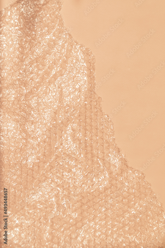 Fototapeta premium Bubble wrap on pink background with natural sunlight
