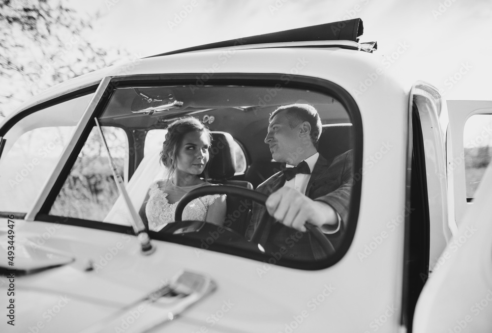 Luxury elegant wedding couple looking each other in stylish retro car. Luxury elegant wedding couple looking each other in stylish retro car.