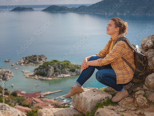 Travel and tourist attractions at Kekova island  Turkey. Woman traveler explores ruins castle of Simena with view of sea bay and Kekova Island with famous flooded city. Tourist attractions in Turkey.