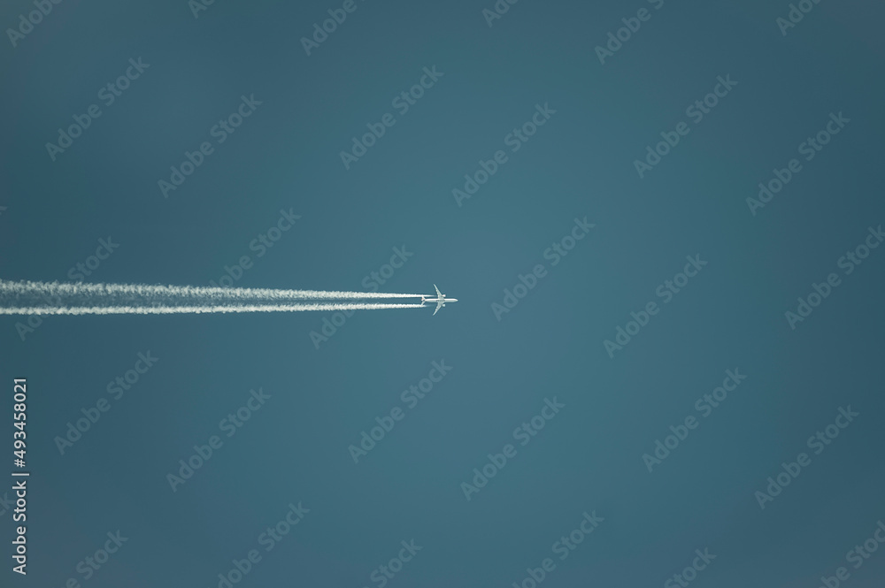 Airplane with white condensation tracks. Jet plane on clear blue sky with vapor trail. Airplane with white condensation tracks. Jet plane on clear blue sky with vapor trail.