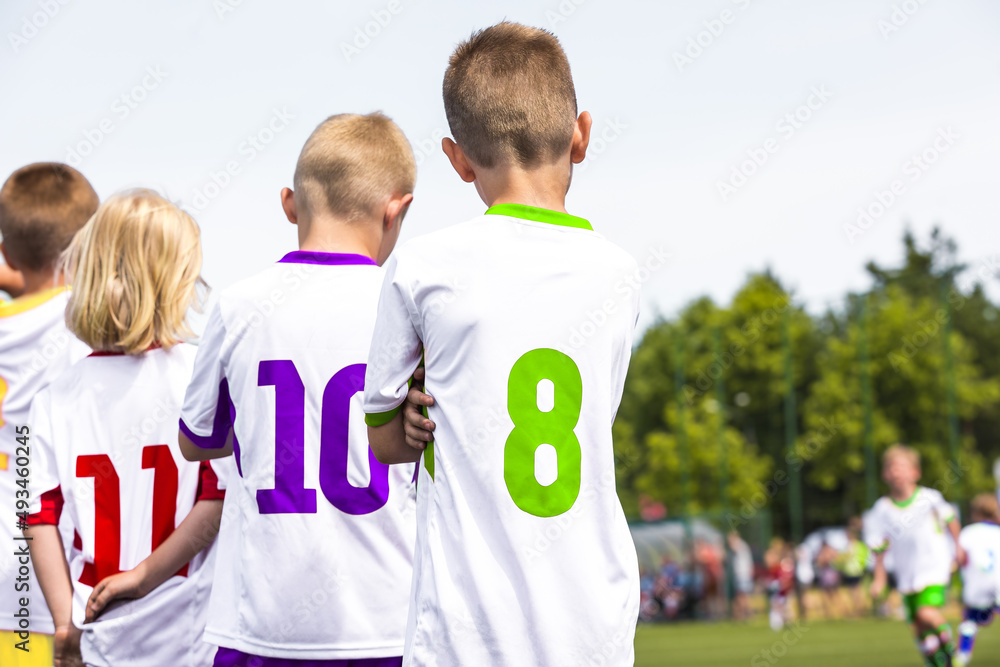Fototapeta premium Children in Colourful Sports Jersey Uniforms. Friends on a Soccer Team Standing United in a Line. Boys in School Sports Team