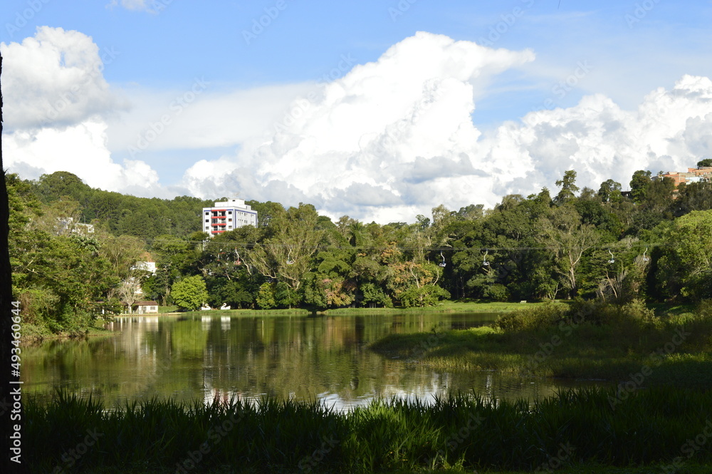 Fototapeta premium Lago com floresta ao fundo com prédio entre as árvores