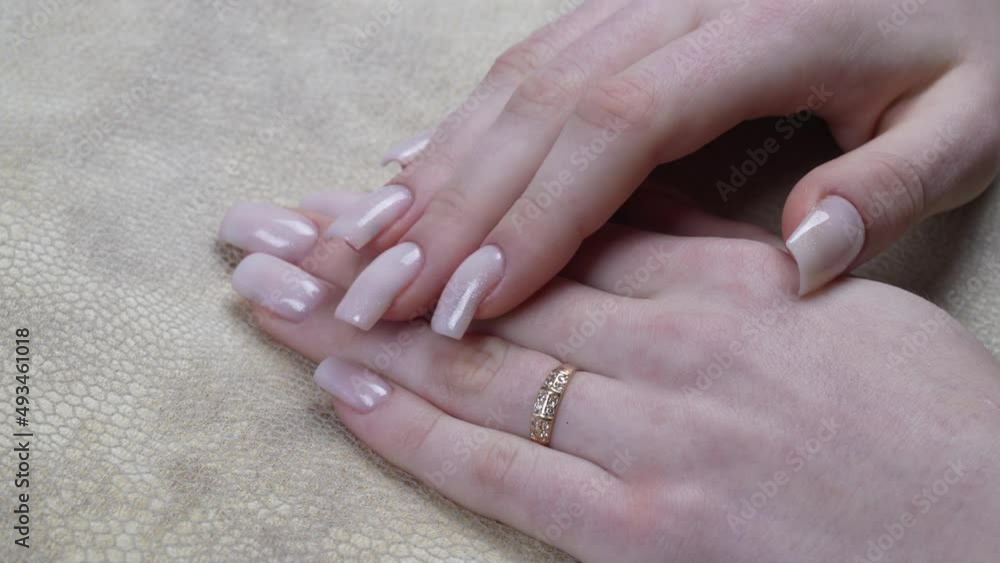 Closeup of beautiful pink nails with glossy shiny design. Spring style of nail design concept Closeup of beautiful pink nails with glossy shiny design. Spring style of nail design concept