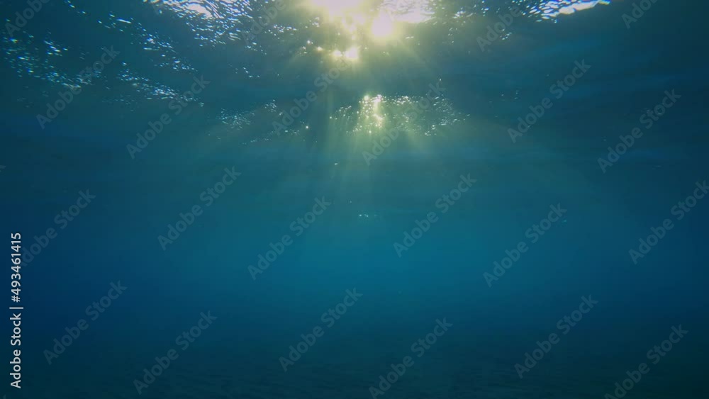 Rays of the setting sun penetrate the water column through the waves on the surface, forming beams of light .. Rays of the setting sun penetrate the water column through the waves on the surface, forming beams of light ..