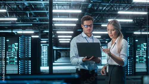 Male and Female Programmers Talking about Work, Solving Problems Together, Using Laptop Computer. Software Development / Code Writing / Website Design / Database Architecture Concept