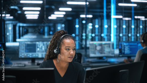 Photography Call Center Office: Portrait of Friendly African American Female Technical Customer Support Specialist Talking on Headset, uses Computer