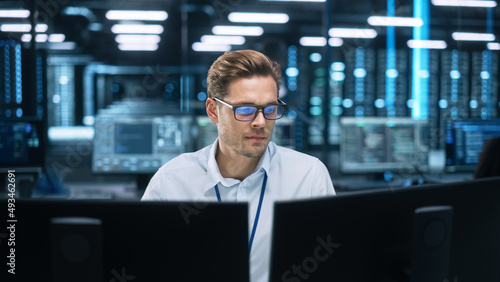 Focused System Administrator or Consultant Look at the Screen and Saves Backup Data in Dark Evening Room Workplace Station Indoors. Network Technologies Concept