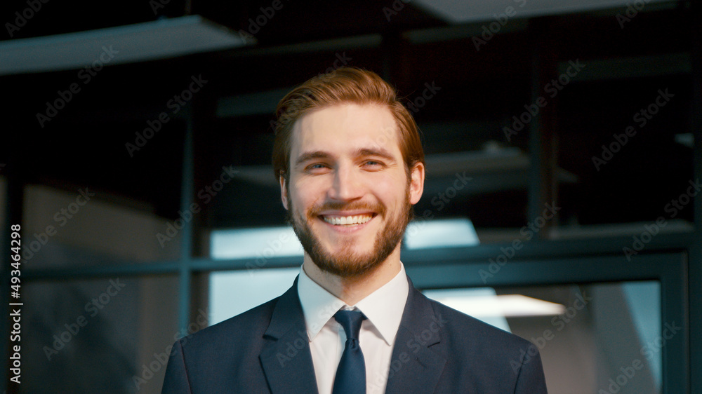 Young businessman smiling and looking at camera. Young man in a suit