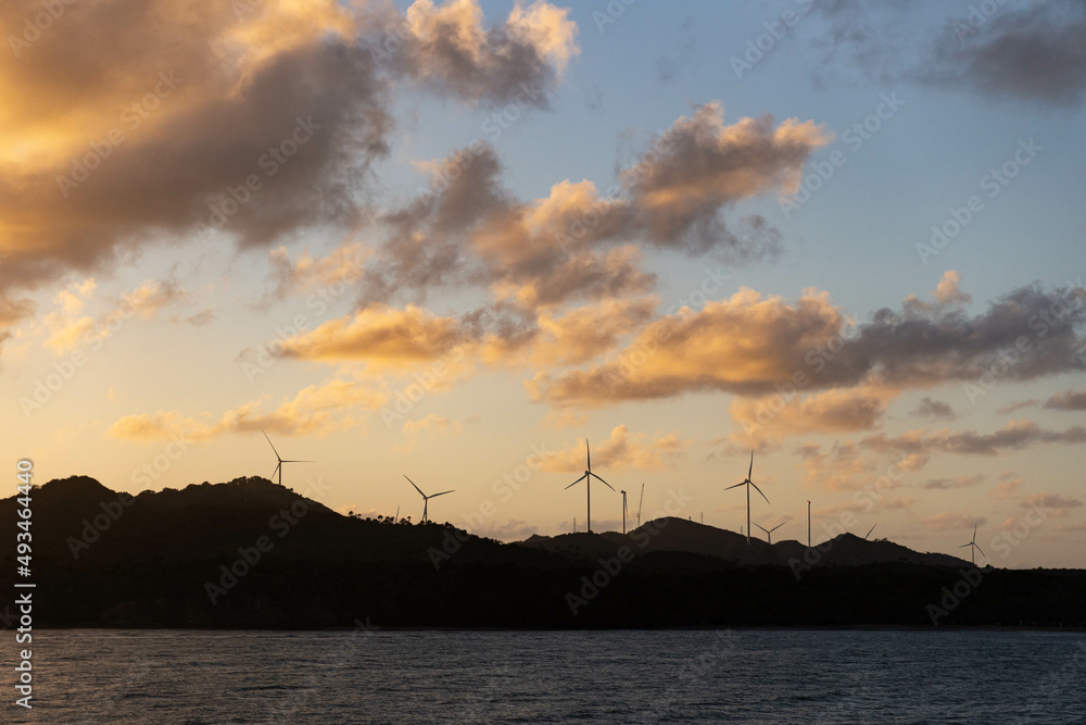 Wind farm. Alternative energy production by the ocean's shore. Wind energy turbines.