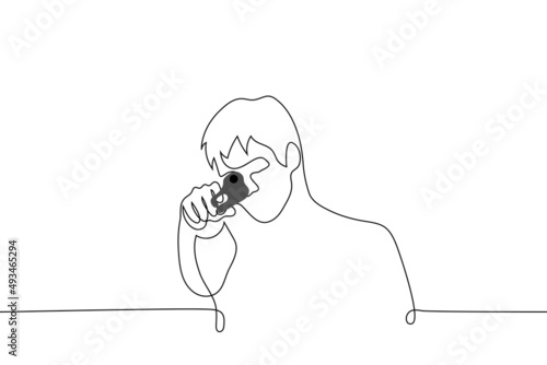 man holding a gun aimed at the viewer - one line drawing vector. shooter aiming