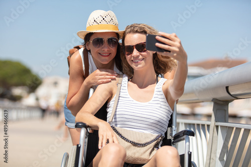couple by the beach taking selfie in a wheelchair