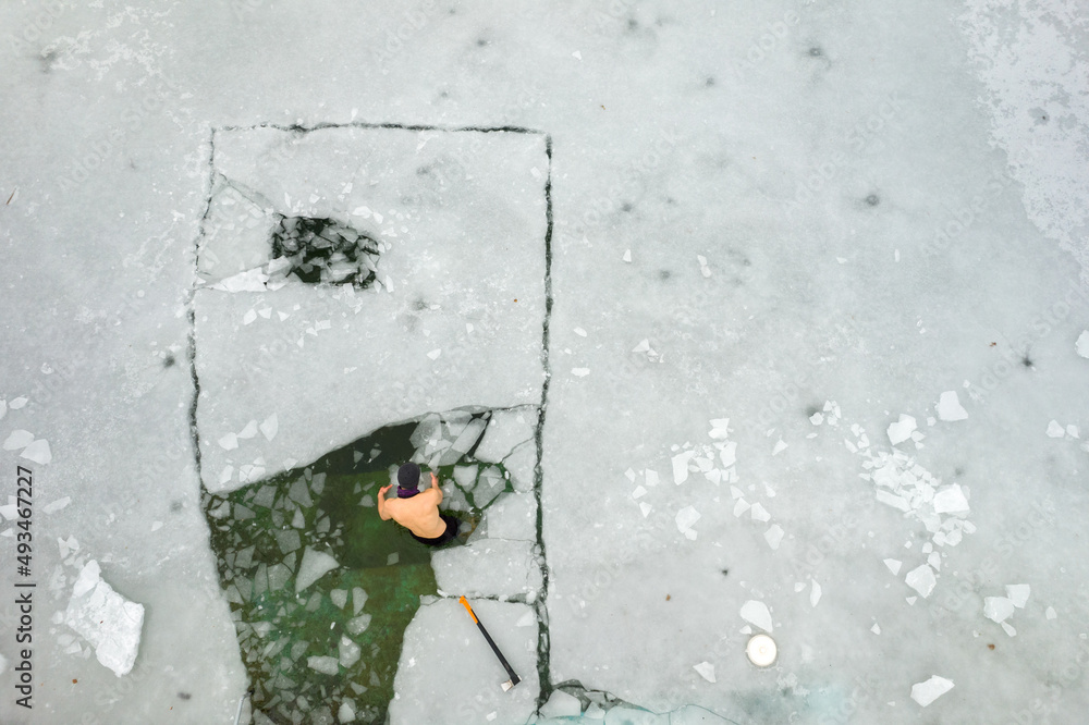 forging a hole in the ice to sea in the lake