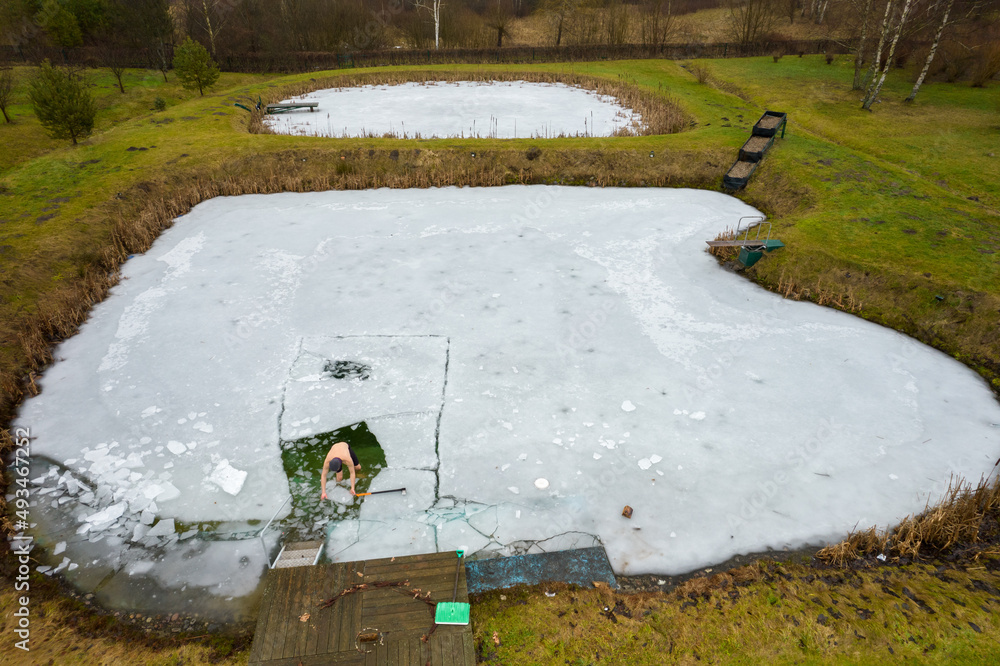 forging a hole in the ice to sea in the lake