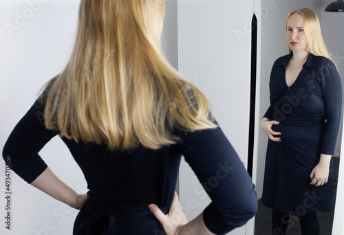 Eating disorder. Woman stands in front of the mirror and sees herself differently. Thin and fat female in frame. Dysmorphophobia or dysmorphia. BDD. Concept of psychological disorders and problems. photo