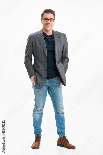 Middle age businessman in business casual. Entrepreneur in jeans and jacket. Mid adult, mature age man, happy smiling. Full length portrait isolated on white. photo