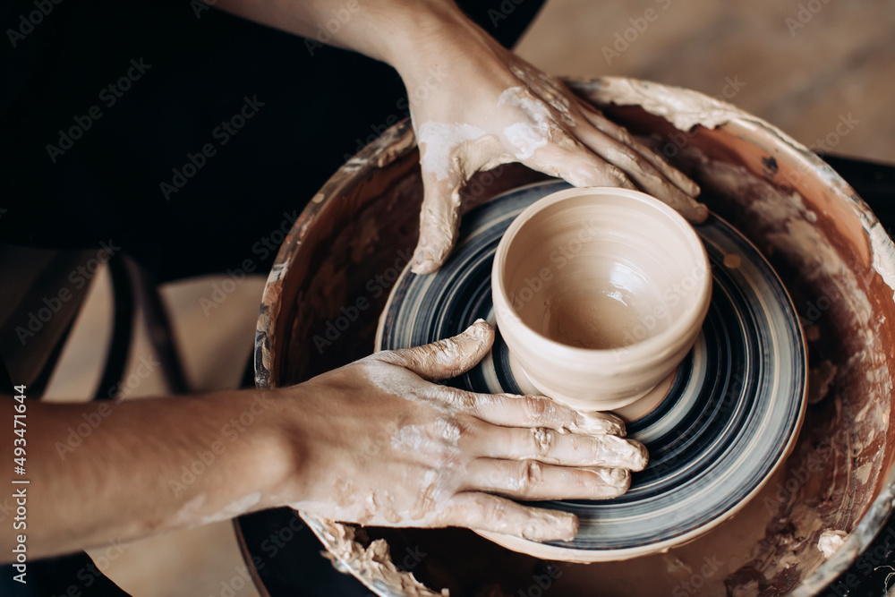 Potter makes a clay jug on a potter's wheel. Handmade Potter makes a clay jug on a potter's wheel. Handmade