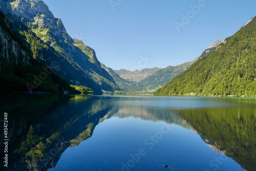Reflection in idyllic mountain lake Kloentalersee in the Swiss Alps. Glarus, Switzerland.