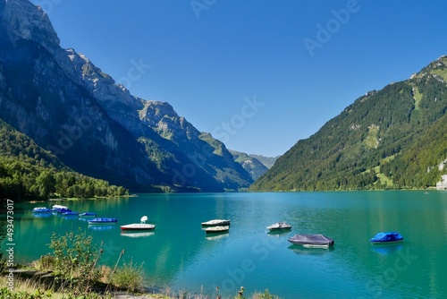 Boats in idyllic mountain lake Kloentalersee in the Swiss Alps. Glarus, Switzerland.