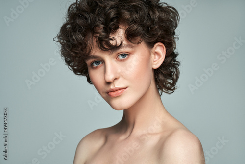 Close-up face of young woman with short curls and fresh skin