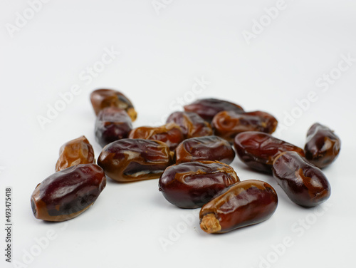 dates scattered isolated on a white background. healthy fruit ramadan concept