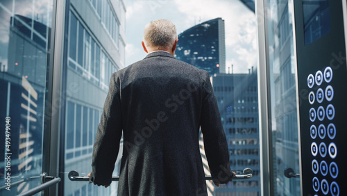 Tableau sur toile Businessman in a Suit Riding Glass Elevator to Office in Modern Business Center
