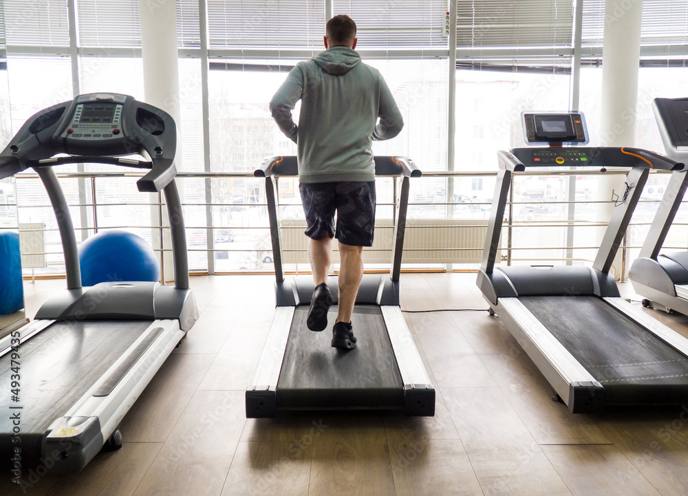 guy jogging on a treadmill in the gym. Fitness, workout and healthy lifestyle