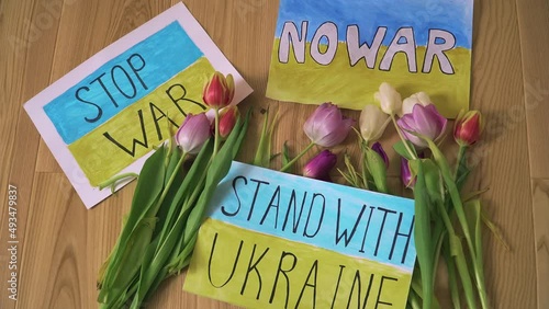 Three motivational packard with anti war texts against armored conflict in Ukraine with flowers on refugee center floor. Crisis, peace, stop aggression in whole world photo