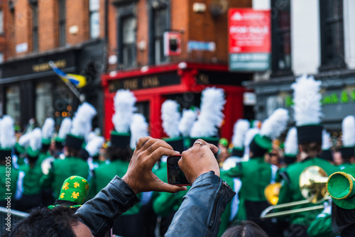Person taking photos of the march, the Saint Patrick's day parade in Dublin 2022