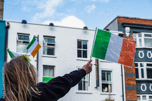 Girl holding irish flag with, Saint Patrick day parade in Dublin, 2022