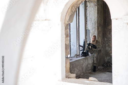 Caucasian military woman in a destroyed building.  © Михаил Решетников
