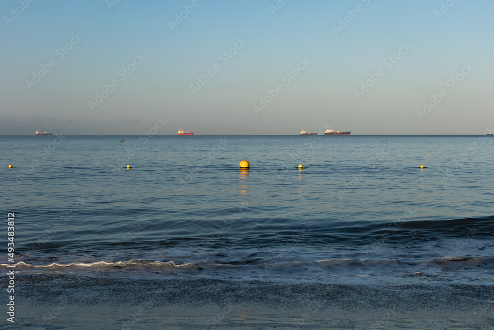 Sea with yellow buoys and boats