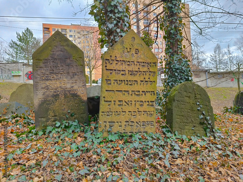 Three old tombstones with script written in Hebrew. The cemetery is situated in the polish city of Cieczyn. photo