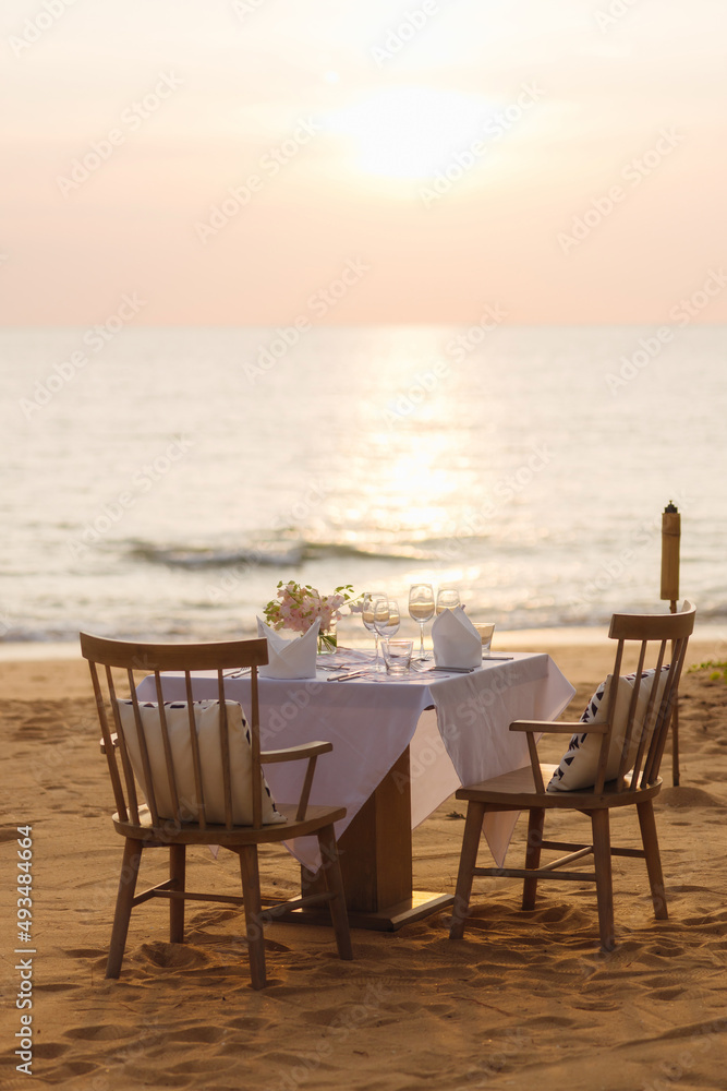 Dinner set for romantic couples on the beach with sunset. Dinner set for romantic couples on the beach with sunset.