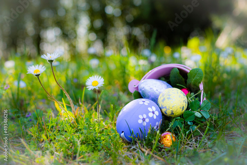 Scena Pasquale con un secchiello rovesciato sull'erba dal quale escono delle uova colorate di Pasqua. Feste di primavera. Celebrazione. Religione. Vacanze. photo