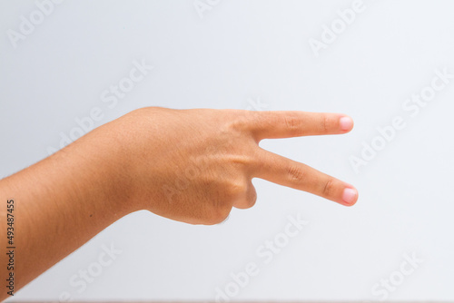 child making number 2 sign on a white background.