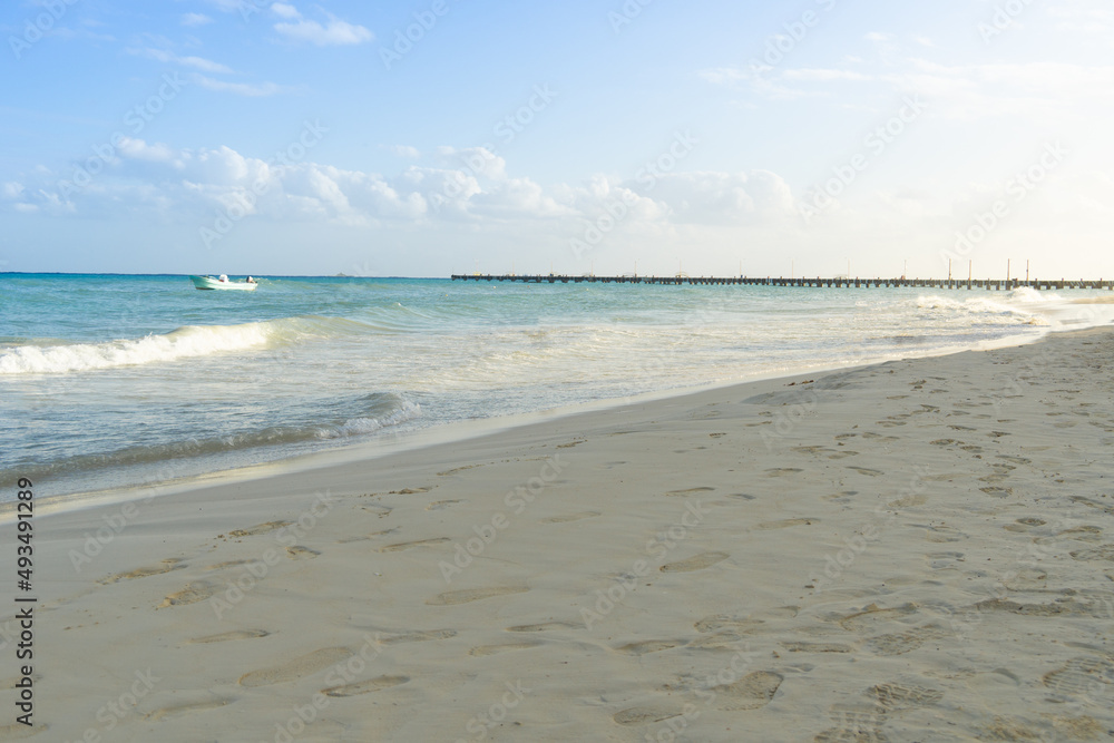 View of the sea, beach and sky. The deserted beach is covered with traces of people. Early morning on the seashore, the pier is visible in the distance. View of the sea, beach and sky. The deserted beach is covered with traces of people. Early morning on the seashore, the pier is visible in the distance.