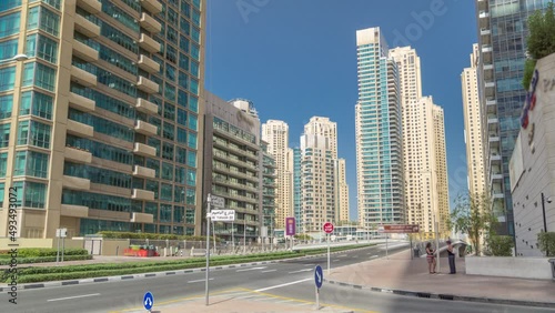 Dubai Marina with Skyscrapers timelapse and traffic on the street near concrete road bridge through the canal photo