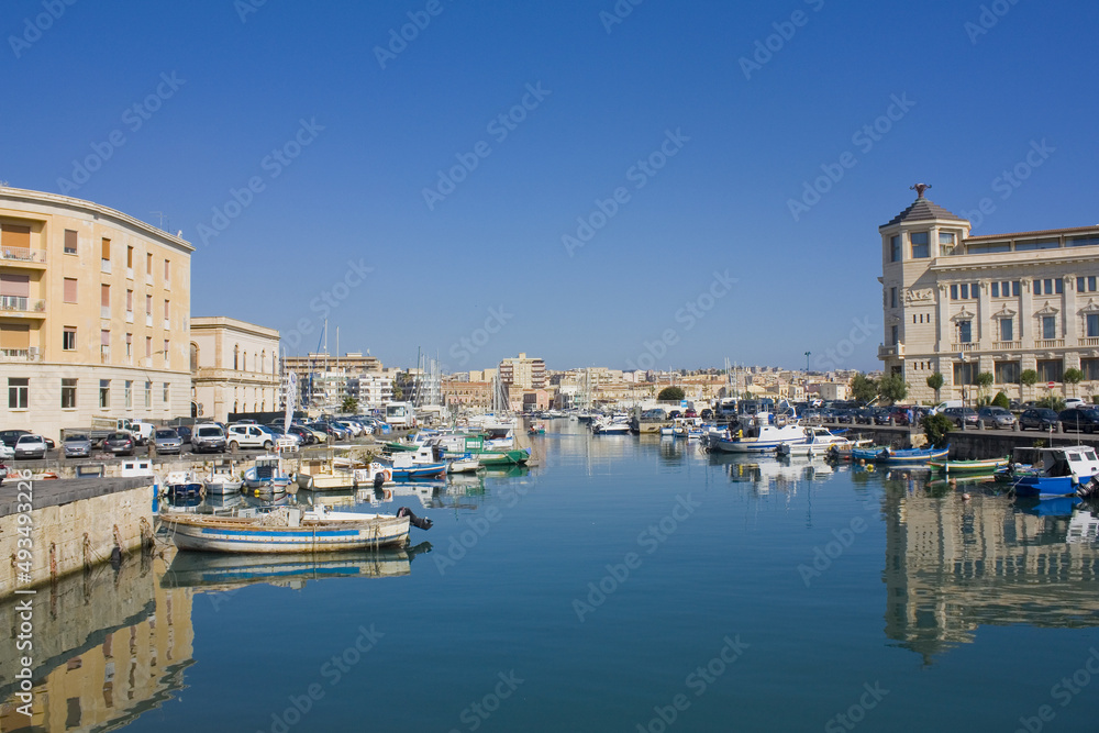 Boats are moored next to the old town of Syracuse, Sicily