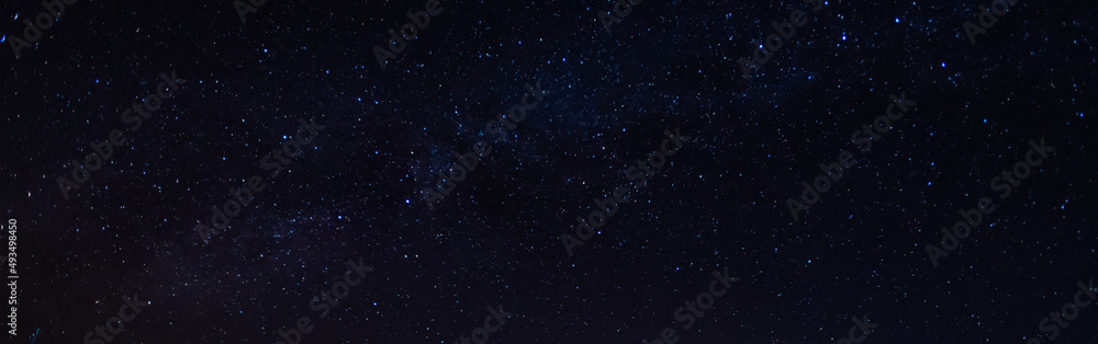 Panorama, blue night sky, milky way and stars on a dark background, universe filled with stars, nebula and galaxies with noise and photo pigmentation by long exposure and white balance selection focus