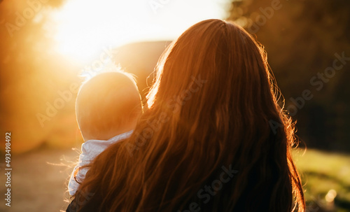 Blurred mom close up with child at sunset.
