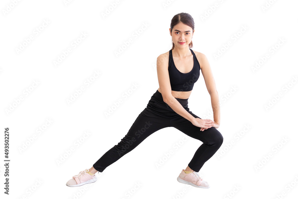 Southeast Asian woman in black workout clothes doing stretches against white background.