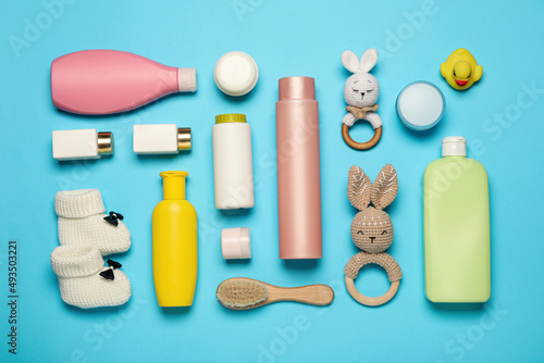 Flat lay composition with baby cosmetic products on light blue background