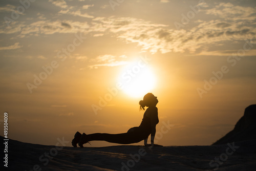 Yoga silhouette. Meditation girl on the background of sea during sunset. Fitness and healthy lifestyle.